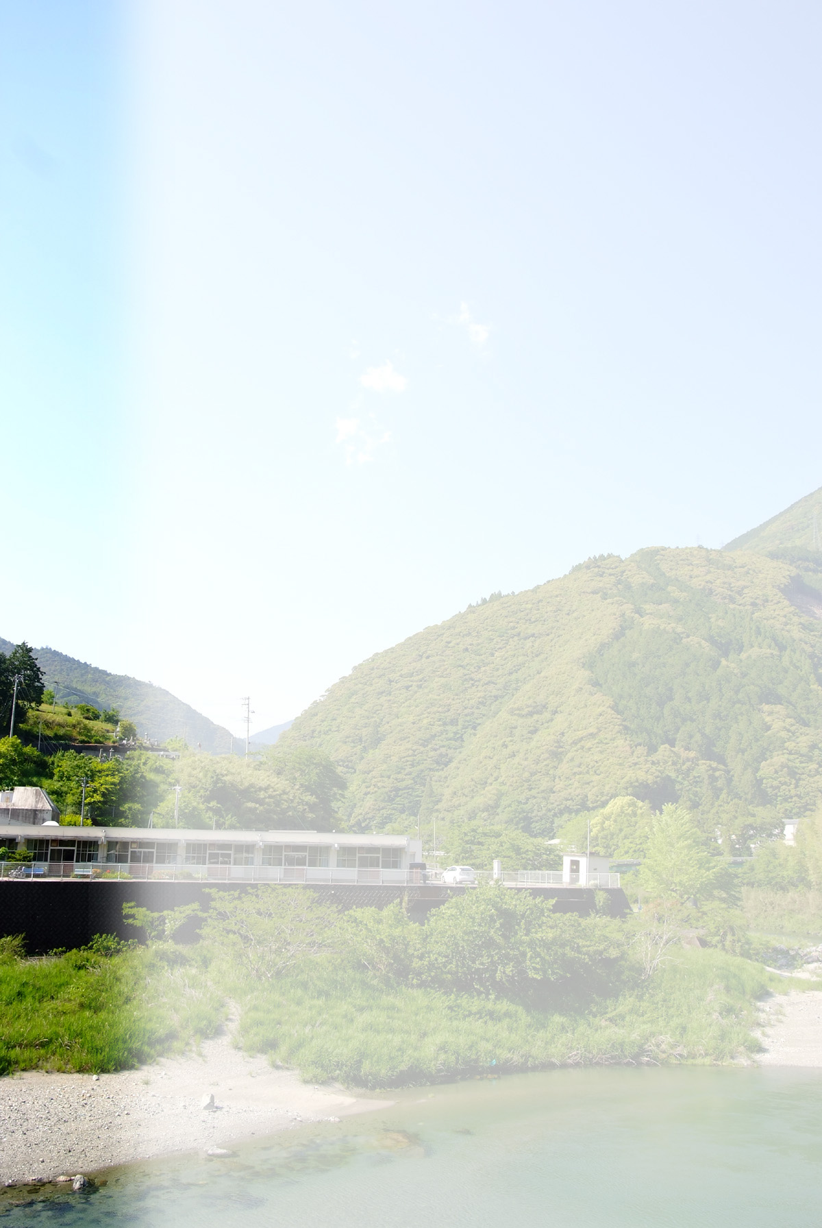 山間の渓流沿いに立つ介護施設の外観。モダンな建物が自然環境に融け込んでいます。
